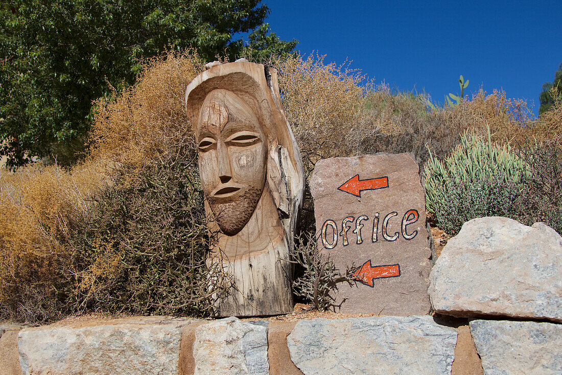 Sign for the office with a wooden carved face; Klein-aus vista namibia