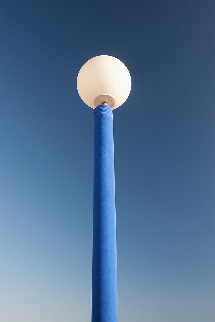 Niedriger Blickwinkel auf einen Laternenpfahl vor blauem Himmel; Malaga, Andalusien, Spanien