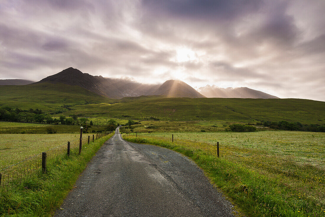 View Along A Road Early In The Morning With The Rising Sun Behind The Black Cuillin Ridge; Glen Brittle, Skye, Scotland