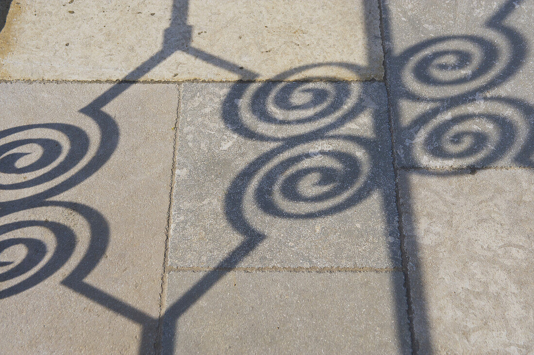 Shadow Of Ornate Fence Detail On The Ground; Cite, France