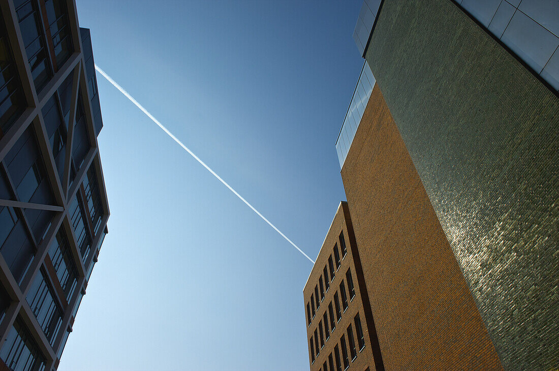 Low Angle View Of Building Facades Against A Blue Sky With A Jet Stream; Hamburg, Germany