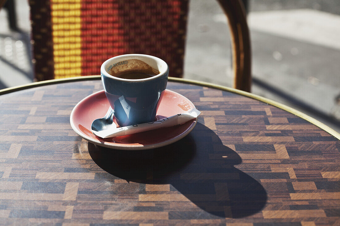 A Cup Of Coffee Sitting On A Table At A Cafe; Paris, France