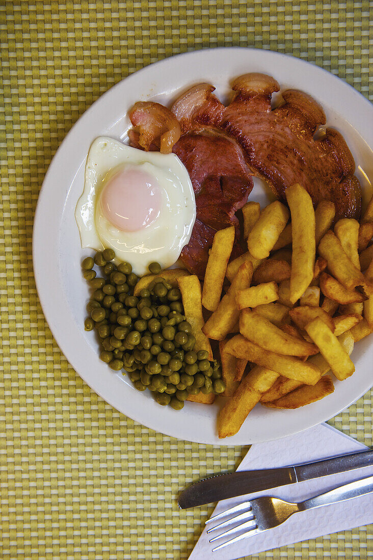 Eine Mahlzeit mit Ei, Pommes frites und Erbsen; London, England