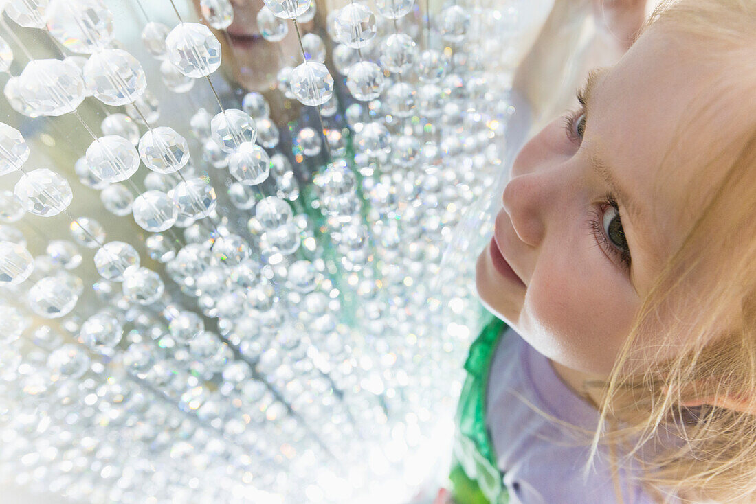 Young Girl Looking At Crystals In Window Display Of The Dubai Mall; Dubai, United Arab Emirates