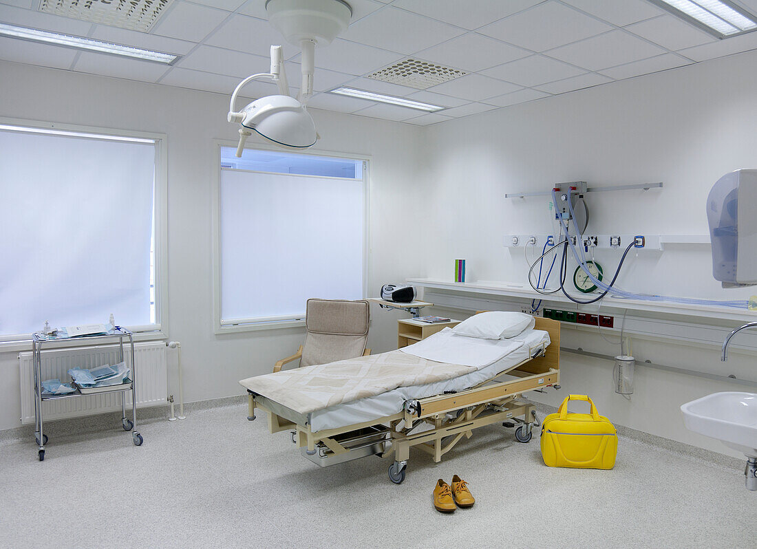 Die Intensivstation einer Kinderstation im Krankenhaus, ein Bett im Familienzimmer, eine gelbe Tasche und Schuhe. Universitätskrankenhaus Tartu.