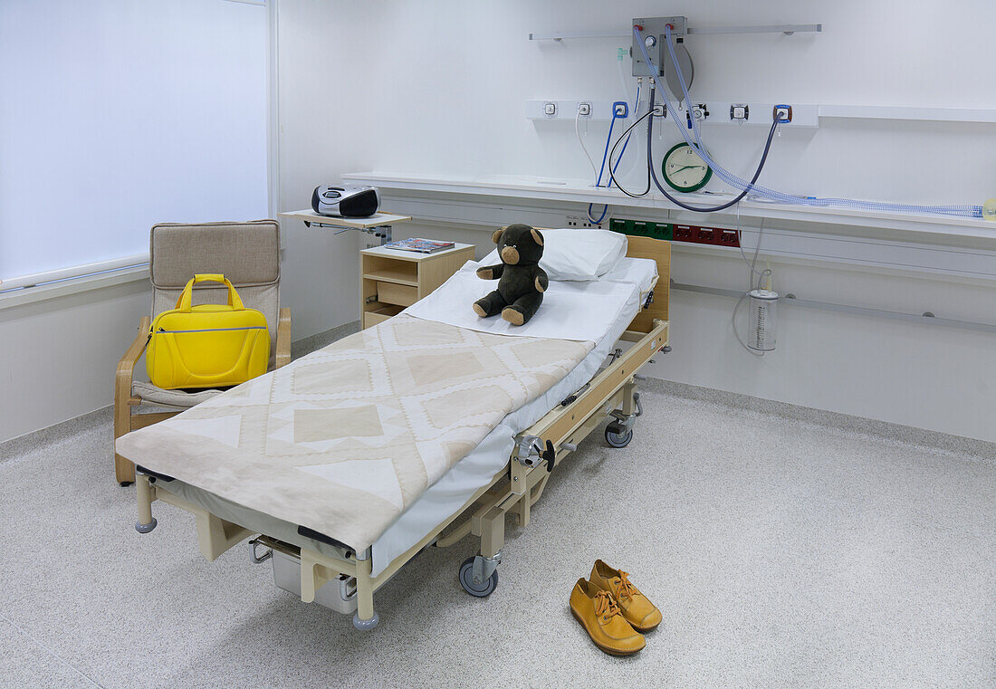 Die Intensivstation einer Kinderstation im Krankenhaus, ein Bett im Familienzimmer, eine gelbe Tasche und Schuhe. Universitätskrankenhaus Tartu.