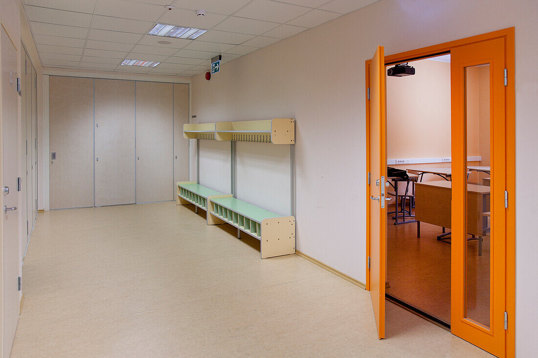 A school corridor and yellow locker room door, bench and coat stand and shoe store. 