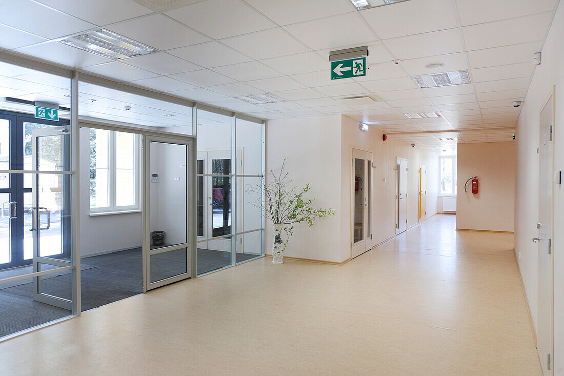 A modern school building, a wide corridor and hallway, light and airy, glass doors. 