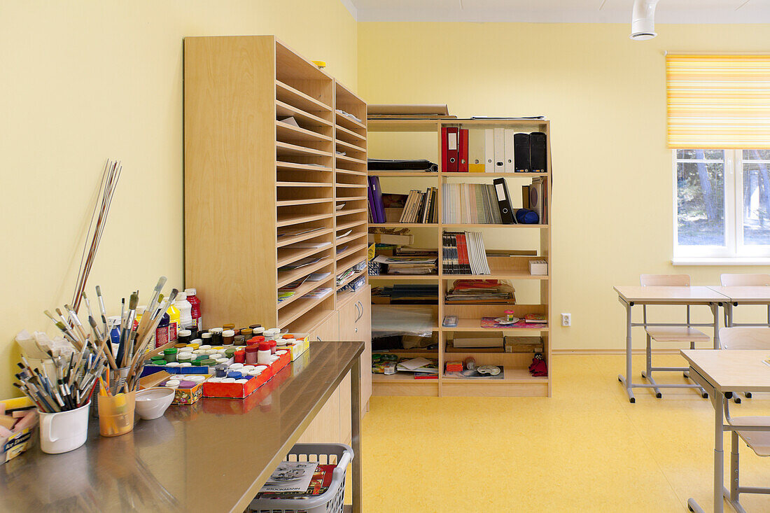 Ein Kunstraum in einer Schule, Klassenzimmer mit Regalen und Geräten, Farben und Pinseln.