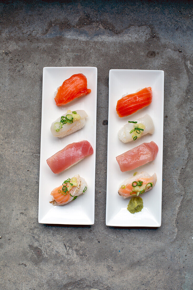 Eine Sushi-Platte mit frischem Fisch und Reis, sorgfältig auf dem Teller mit Garnierungen angerichtet. 