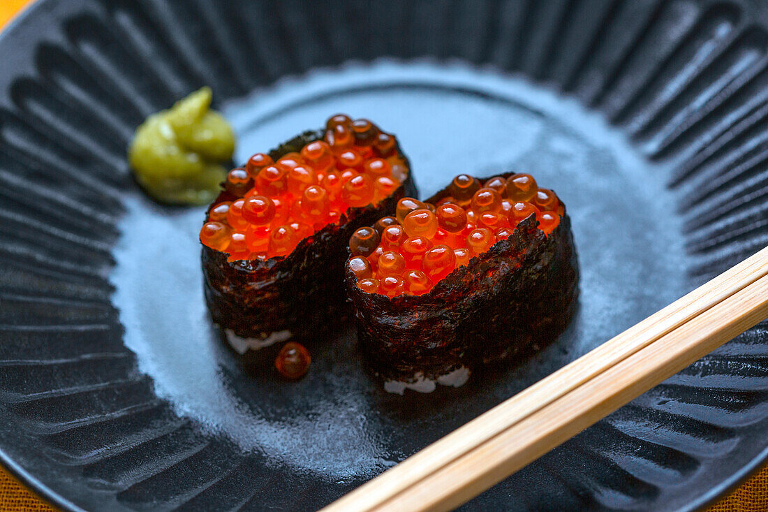 Ein Teller mit zwei Portionen Sushi, in Seetang eingewickelter Reis mit Fischrogen. 