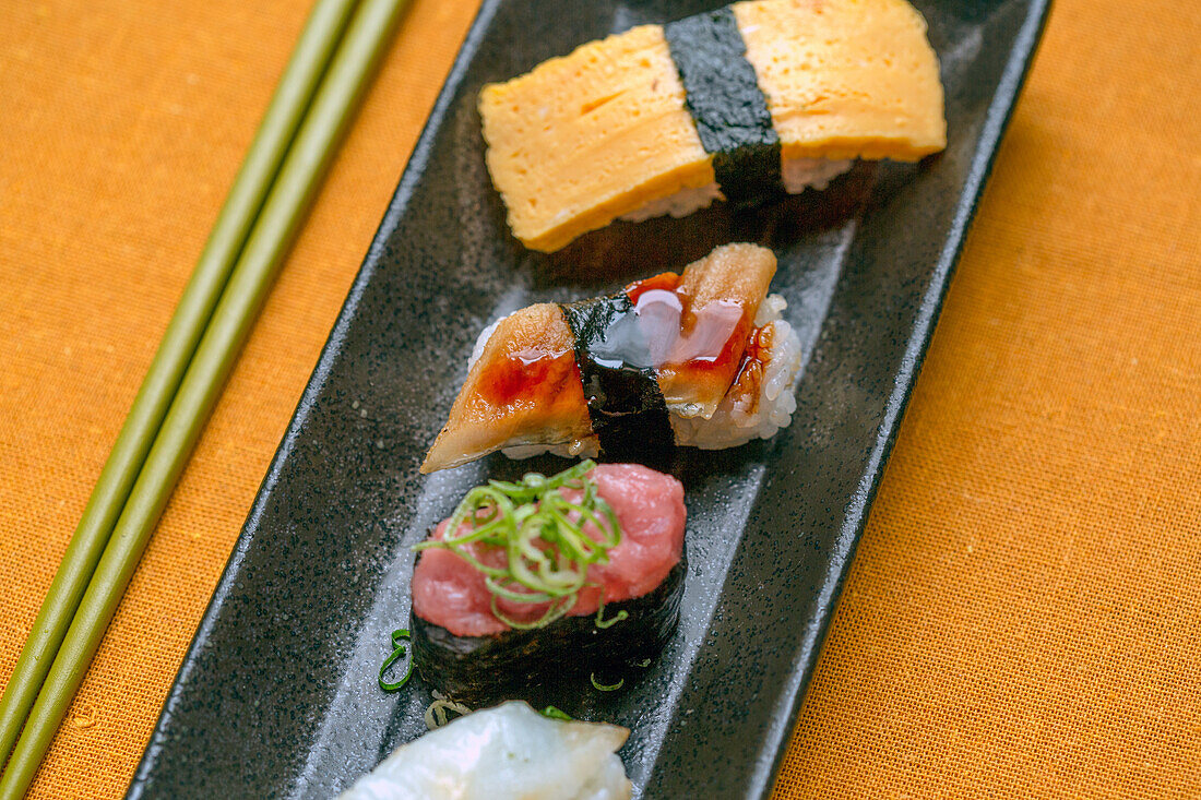 Sushi platter, a selection of raw fish and rice snacks with chopsticks. 