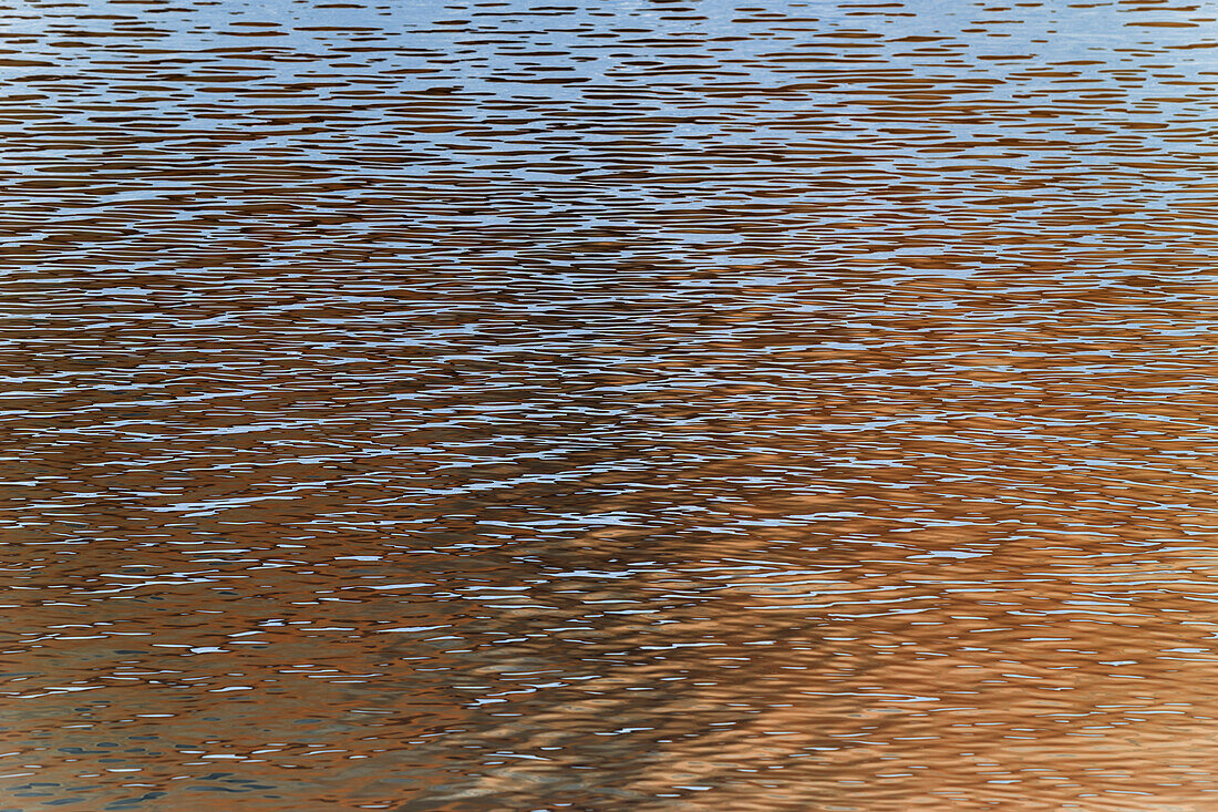 Details auf der Wasseroberfläche eines Flusses, Reflexionen und Abstraktionen, Wellen und Muster. 