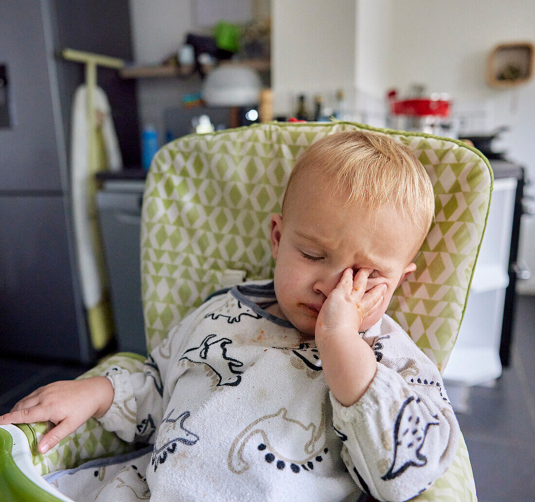 Toddler reaching up and touching appliance in kitchen