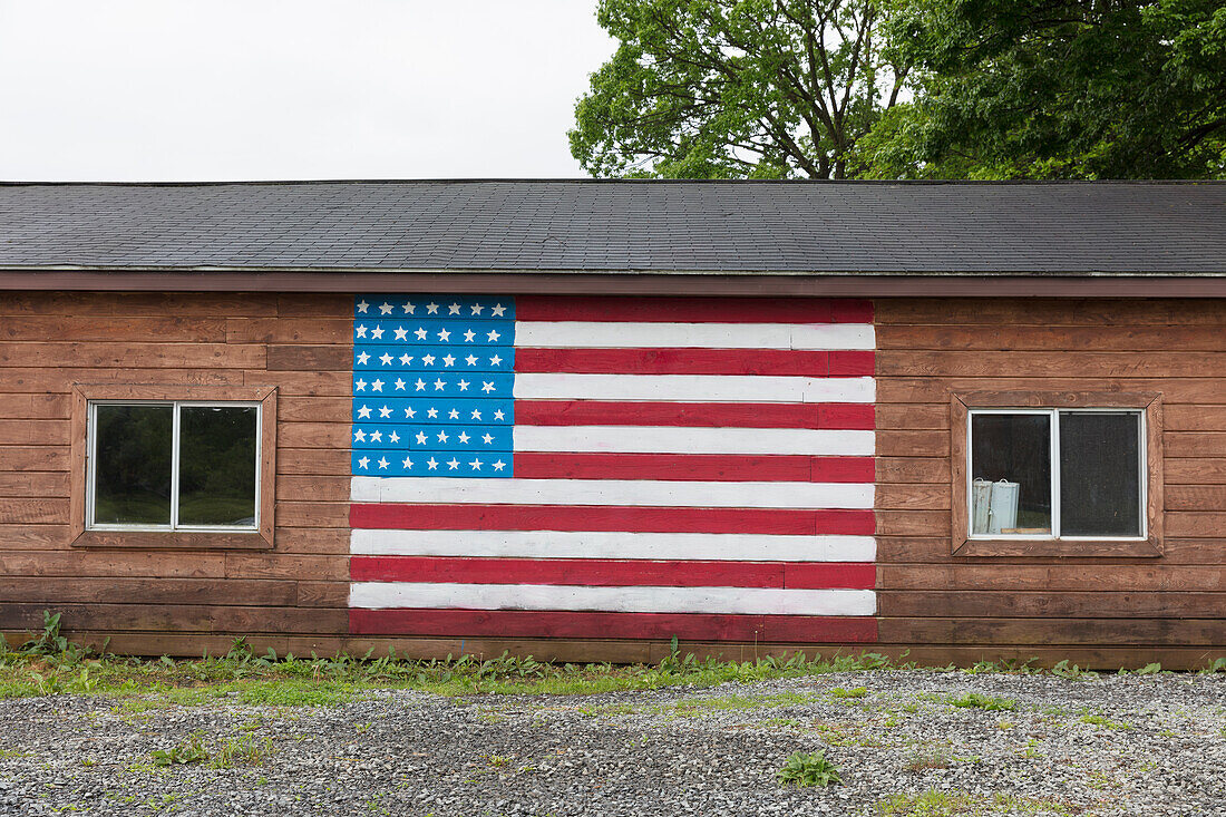 Eine amerikanische Flagge auf einem leeren Gebäude an einer Straße in einer Kleinstadt.