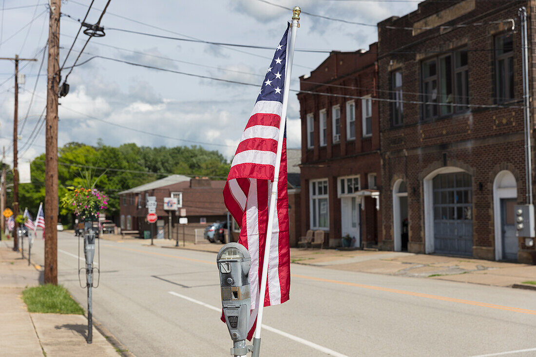 American flag fluttering in the breeze on a deserted main street.