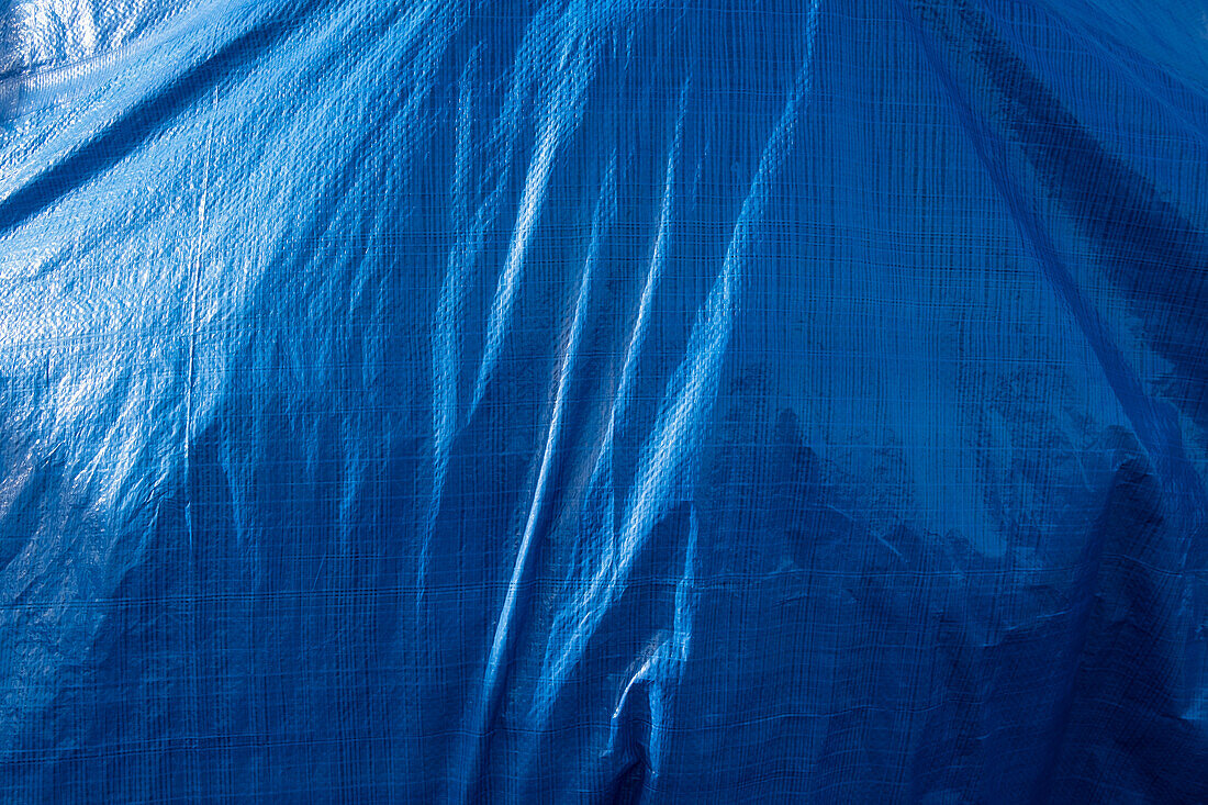 A blue tarpaulin covering a hidden object. 