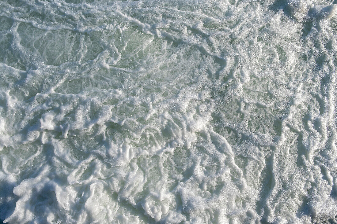 The surface of churning ocean water, overhead view.