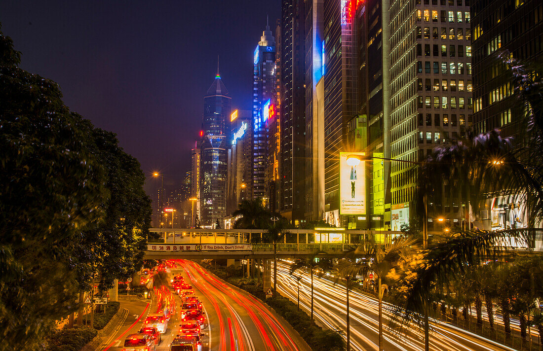 Hongkong, China. Downtown Verkehr in der Gloucester Road in der Nacht mit Autos streifen auf der Straße mit Wolkenkratzern an den Seiten der Central Hong Kong District