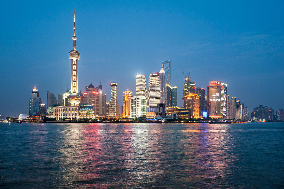 Pearl Tower over Pudong district skyline and Huangpu River Shanghai, China.