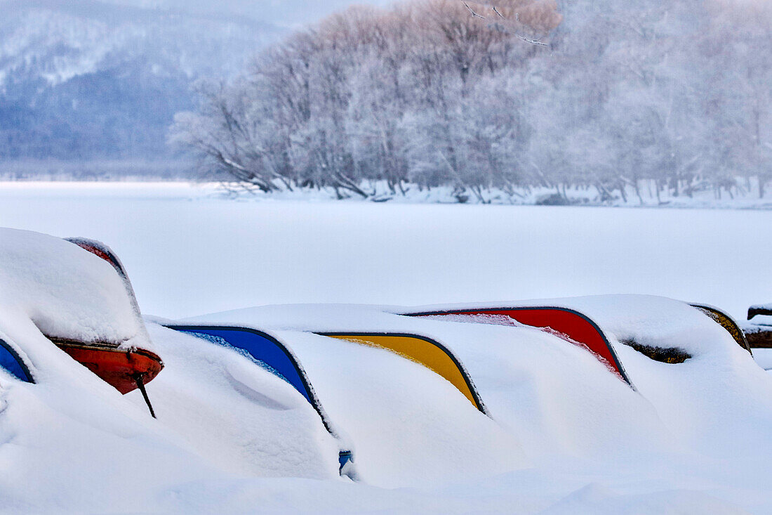 Japan, Hokkaido, Kussharo-See. Bunte Kanus im Schnee