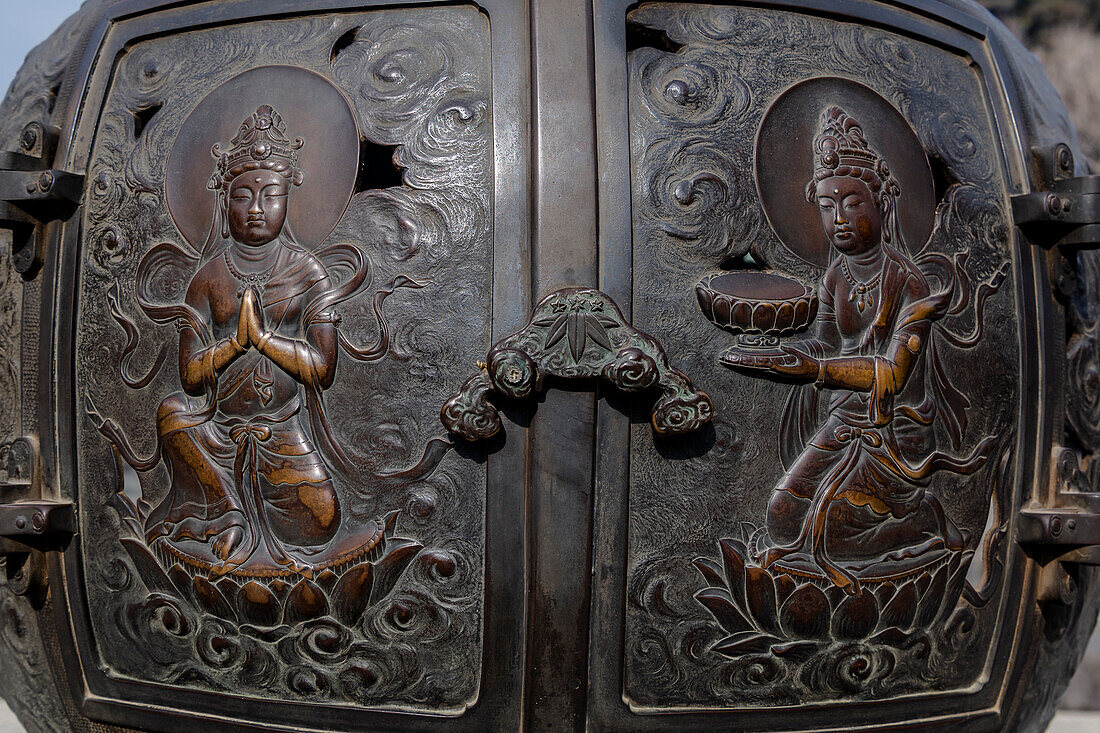 The ornate, engraved bronze doors to the outdoor incense burner of the Daibutsu, Kamakura, Japan