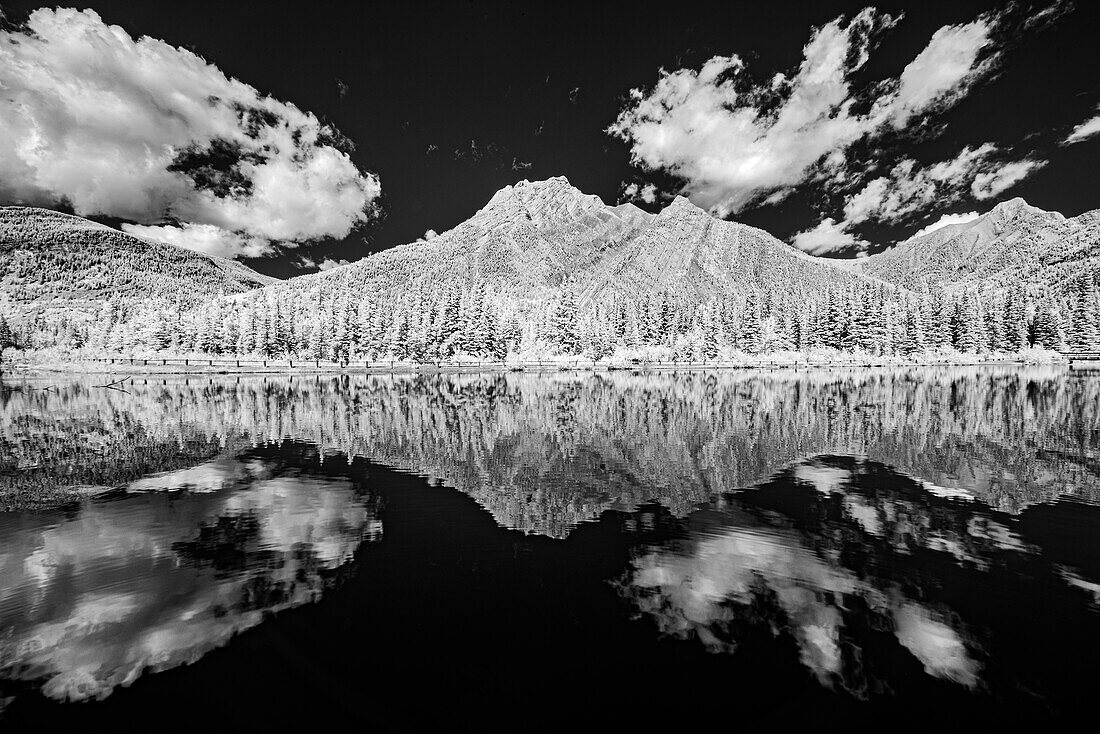 Canada, Alberta, Kananaskis Provincial Park. Black and white of clouds reflected in Lorette Ponds