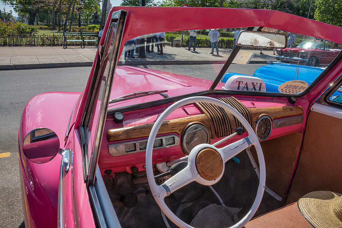 Blick auf den Fahrersitz eines klassischen rosafarbenen amerikanischen Cabriolets in Vieja, Alt-Habana, Havanna, Kuba.