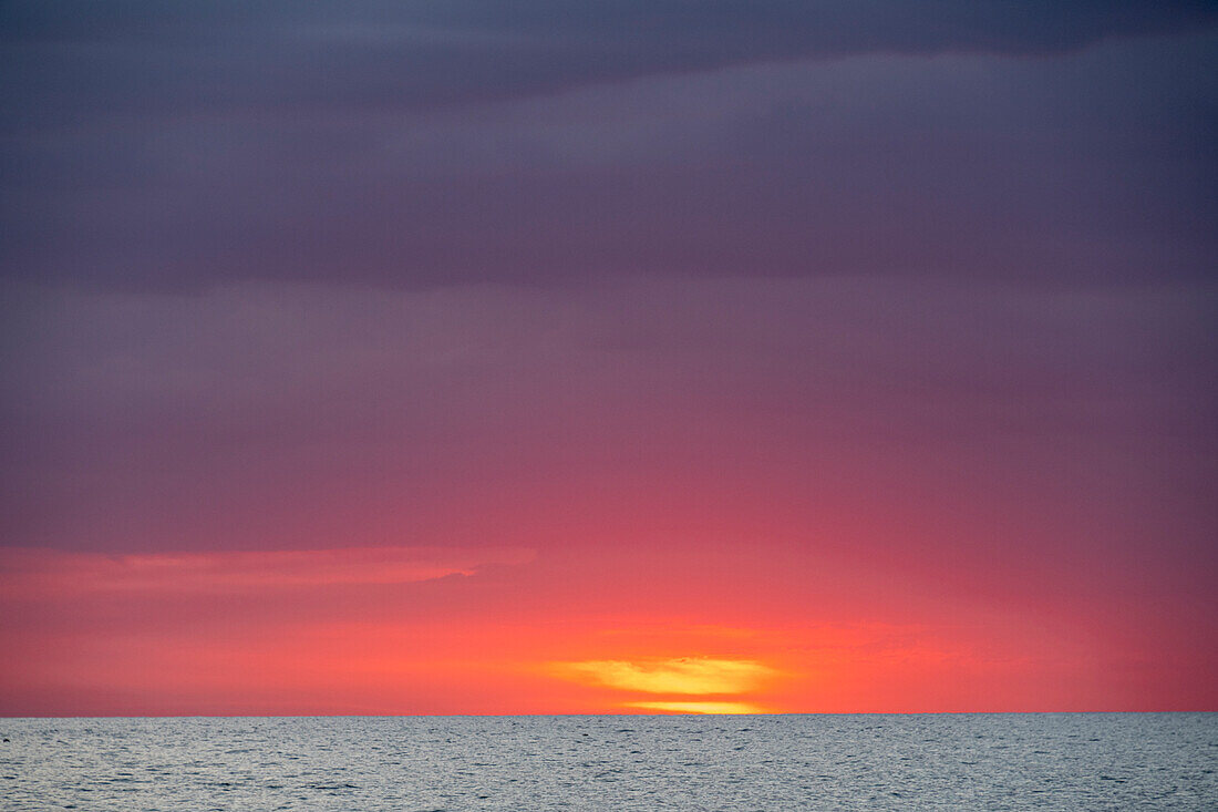 Sonnenuntergang mit Wolken über dem Ozean von La Boca, Kuba aus gesehen