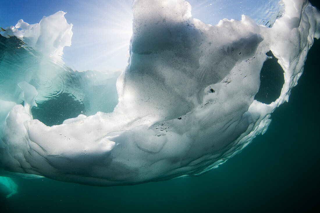 Canada, Nunavut Territory, Underwater view of melting iceberg floating in Hudson Bay on summer morning