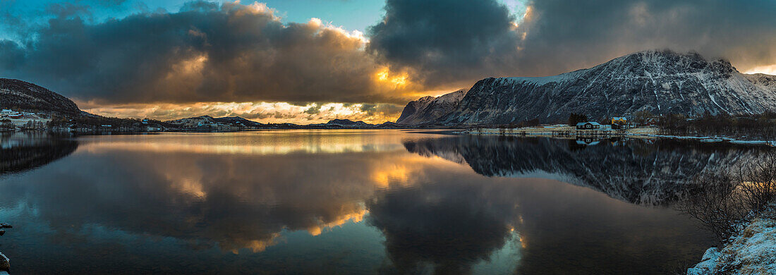 Europe, Norway. Snow covered mountains surround the still waters of Stullbruvaknet near Leknes on Vestvagoy, a part of the Lofoten Islands in Nordland.