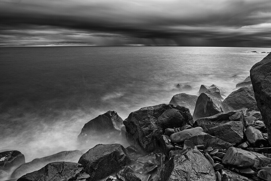 Canada, Quebec, Ruisseau Castor. Shoreline rocks on Gulf of St. Lawrence in storm light