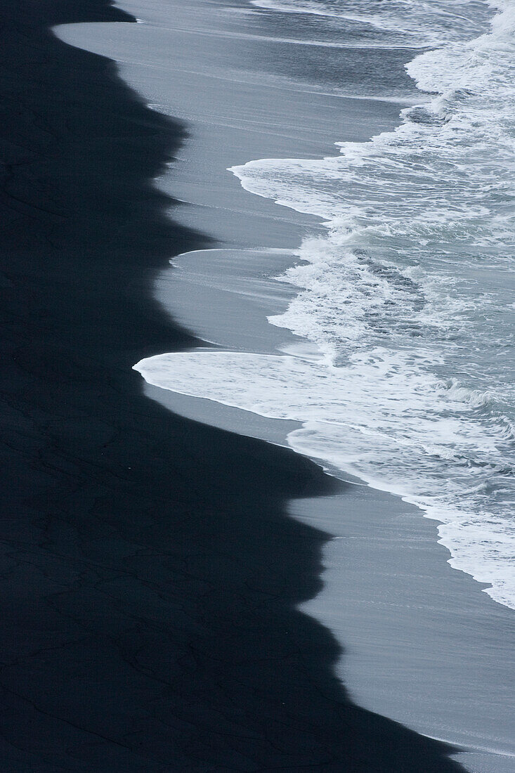 Iceland, Ingolshofdi, Water Rushing Up on Lava Sand