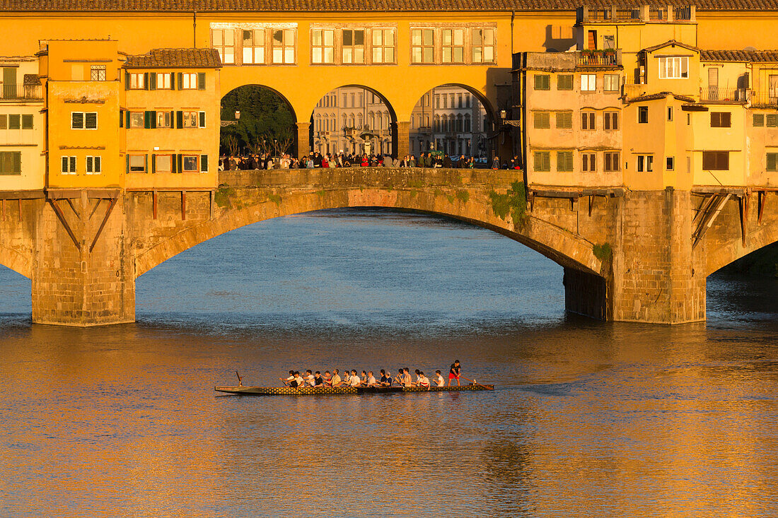 Italien, Florenz. Das goldene Licht des späten Nachmittags beleuchtet die Ponte Vecchio, Florenz' historische Brücke über den Fluss Arno.