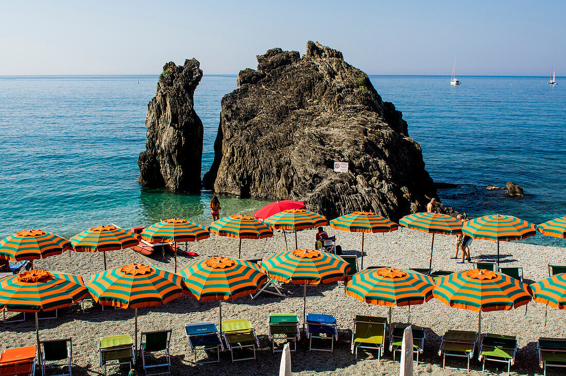 Beach umbrellas lining the beach in Monterosso al Mare, Cinque Terre, Italy.