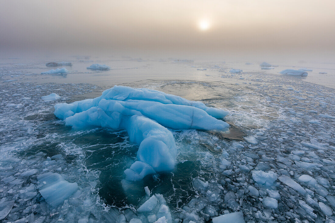 Norwegen, Svalbard, Nordaustlandet. Eismuster und Nebel bei Sonnenaufgang