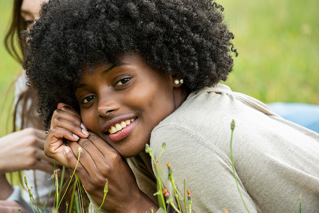 Smiling young woman lying in park