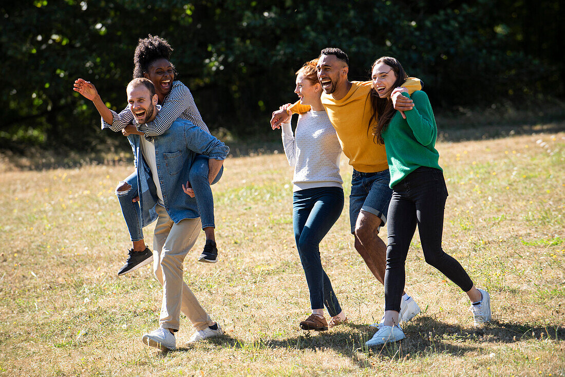 Glückliche junge Freunde haben Spaß im öffentlichen Park