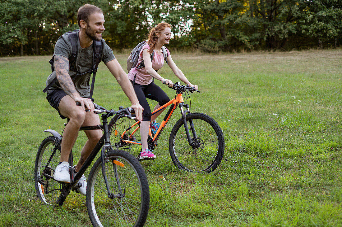 Young couple cycling in forest