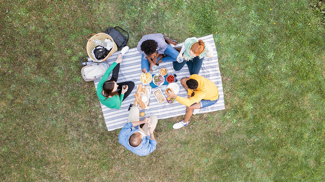 Happy young friends having a picnic in garden