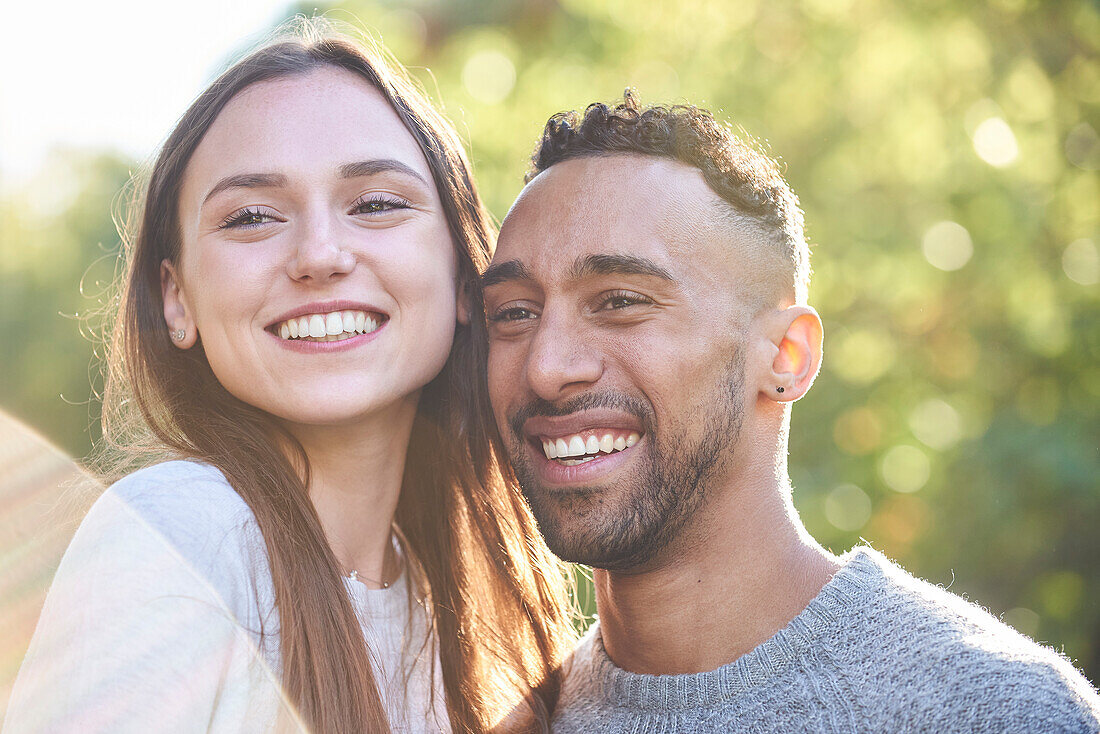 Smiling young couple looking away in public park