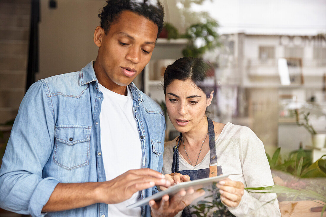 Inhaber eines kleinen Unternehmens richten einen Online-Shop auf einem digitalen Tablet ein