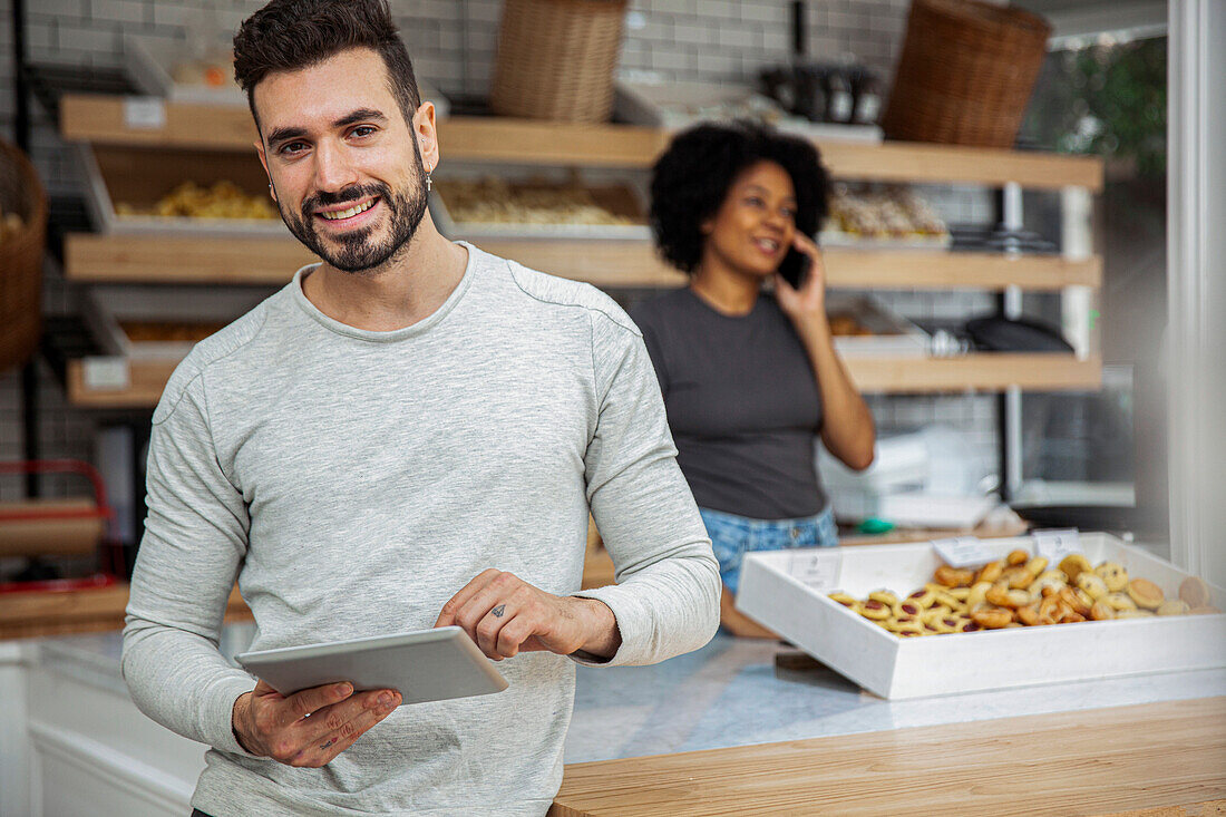 Bäckereibesitzer hält digitales Tablet in der Bäckerei