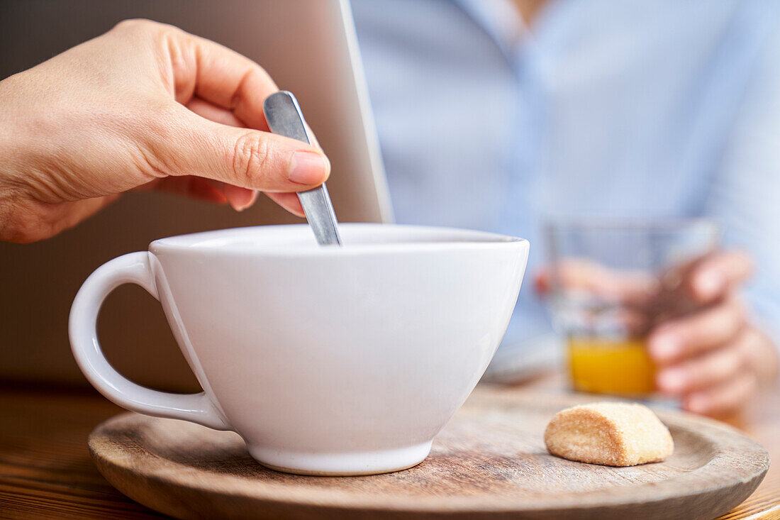 Close-up shot of woman's hand stirring coffee with spoon