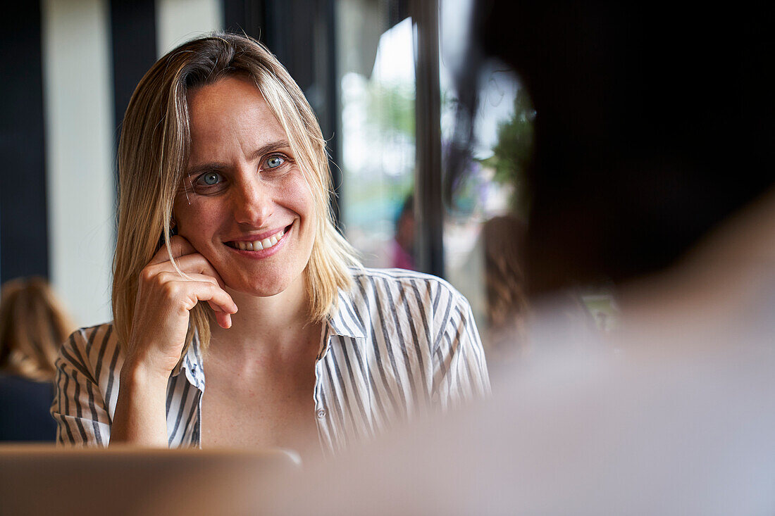 Medium front shot of attractive business woman and of colleague's back at company's cafeteria