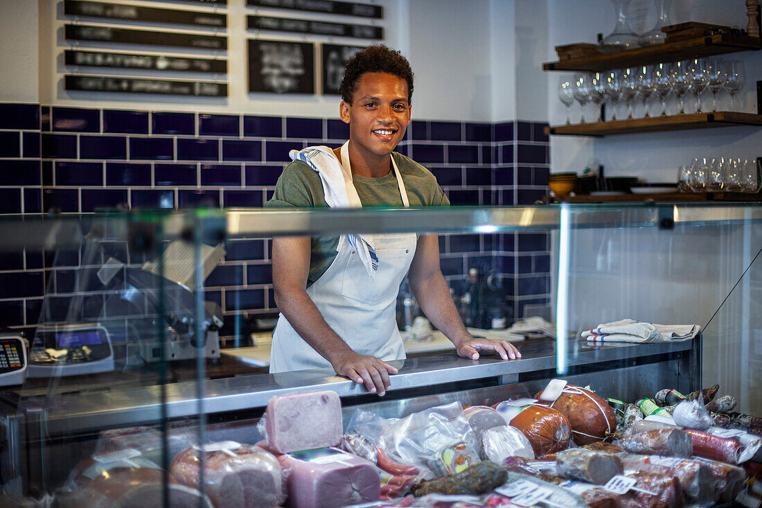 Latin American man standing behind counter at grocery store