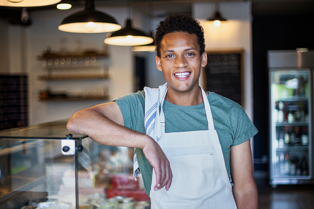 Latin American grocery store worker leaning on counter