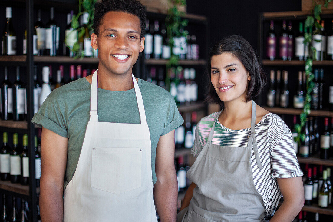 Liquor store owners wearing apron looking at the camera