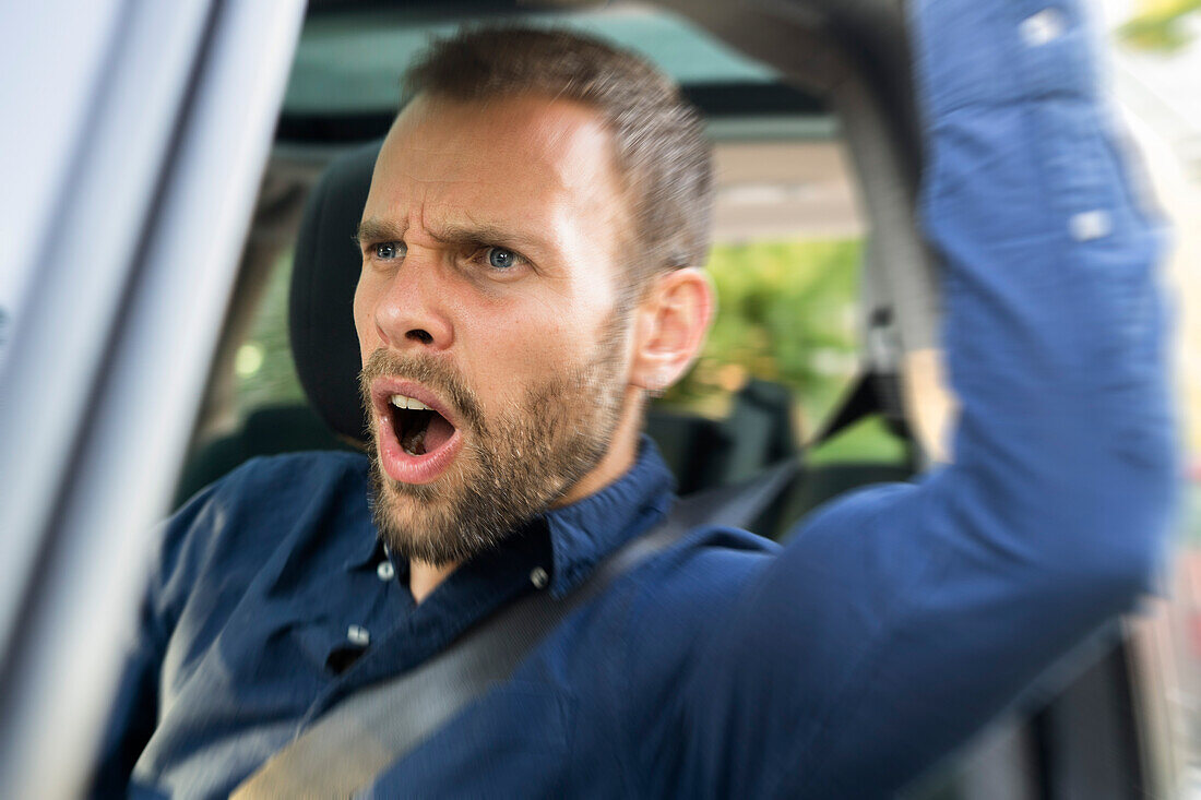 Frustrated young man driving a car