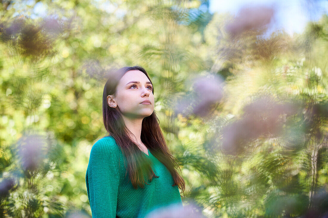 Thoughtful young woman standing in public park